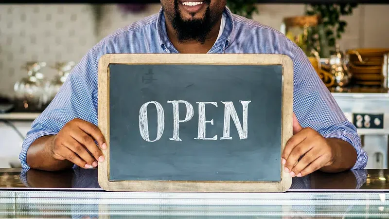 Man holding Open sign